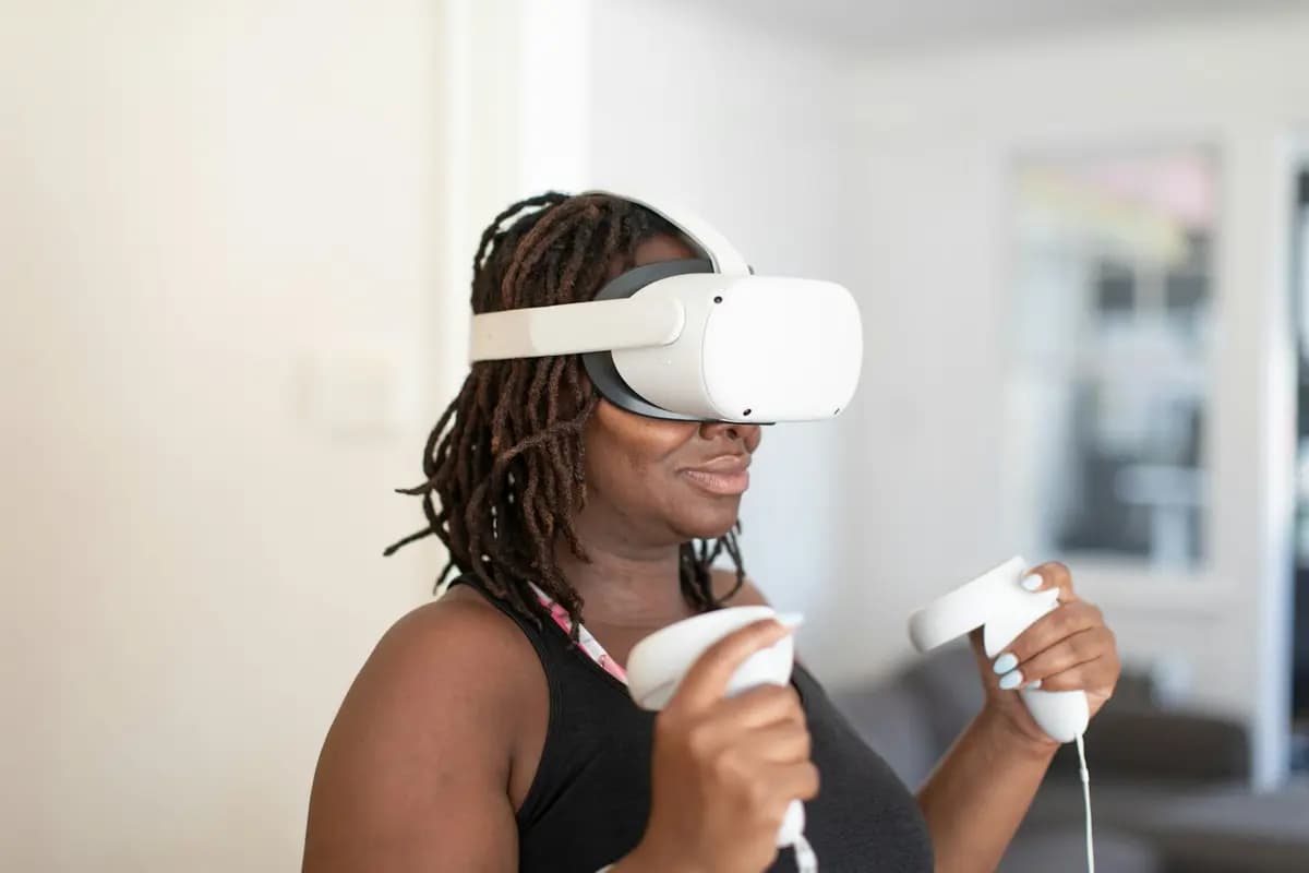 A woman wearing a VR headset and holding its two controllers